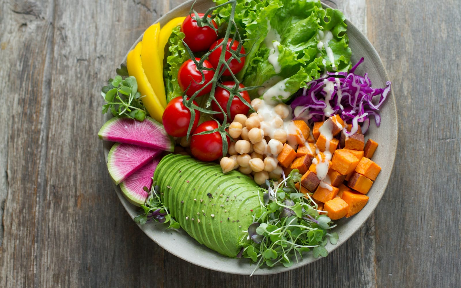 A colourful salad bowl with avocado, chickpeas, tomatoes and sweet potato